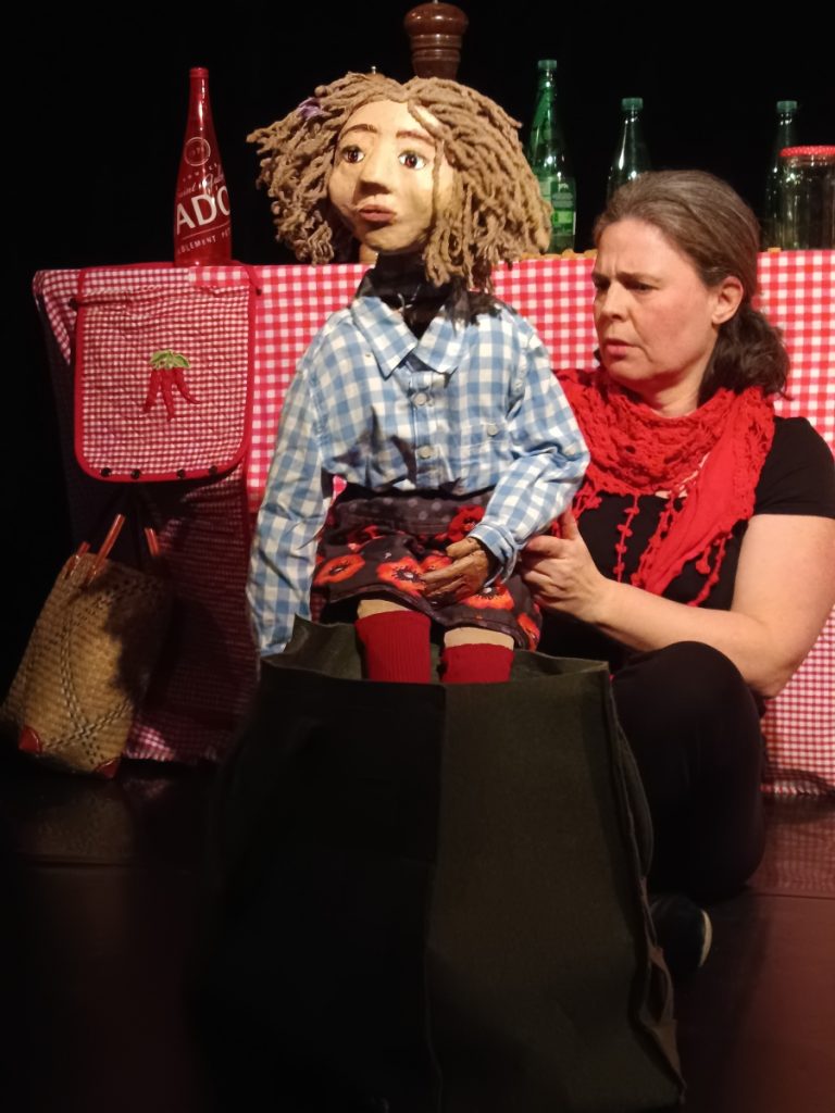 Marionnette portée du petit chaperon rouge laisse apparents les matériaux simples (kraft, laine, cintre)
